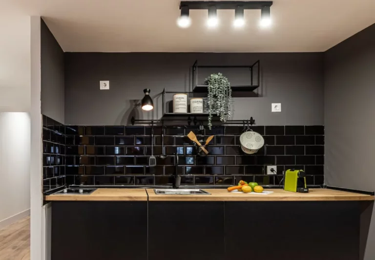 Cocina en negro con encimera de madera en el apartamento Queen's Chueca II, Madrid