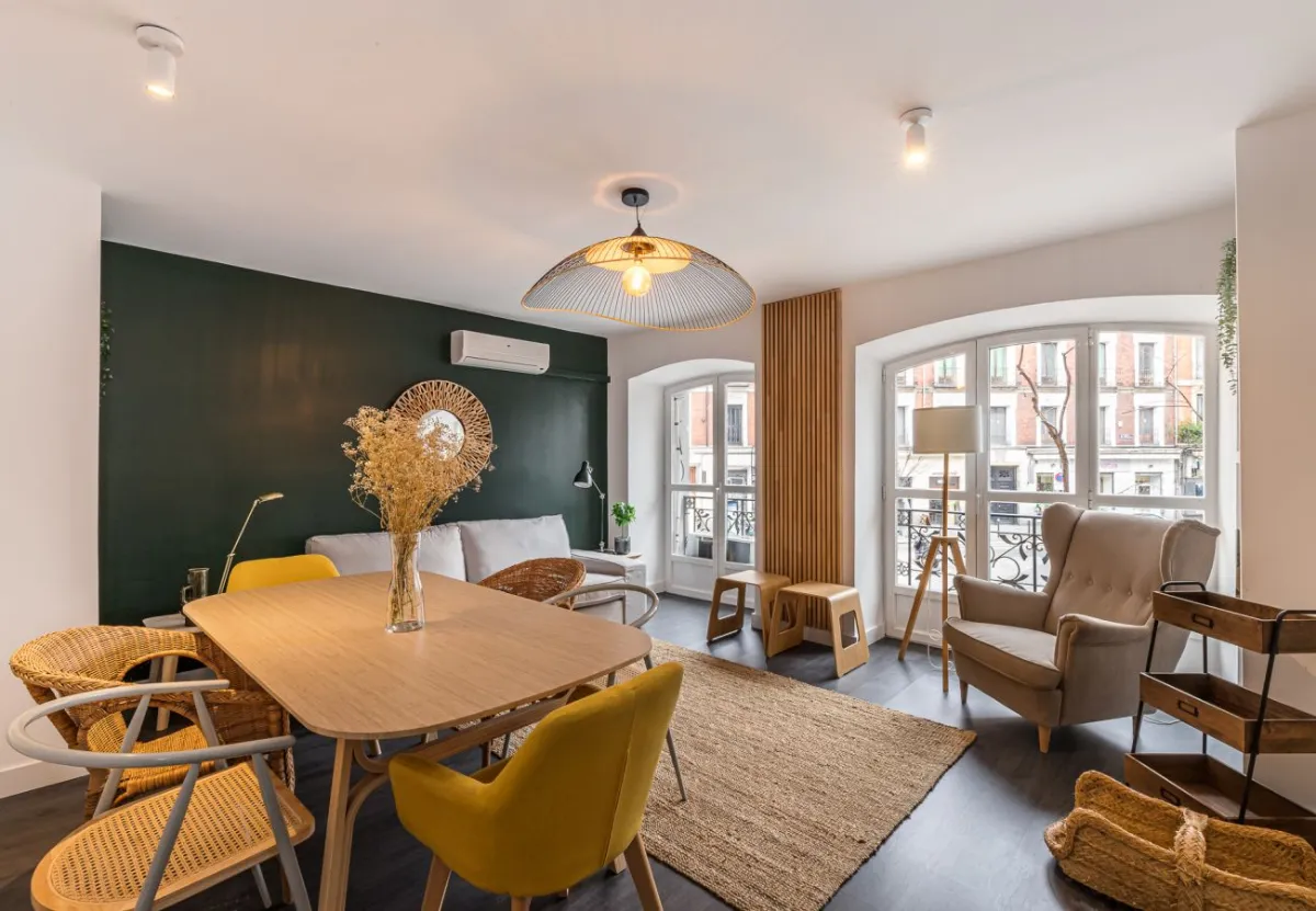 Salón comedor con pared verde en el apartamento Queen's Plaza Mayor I, Madrid