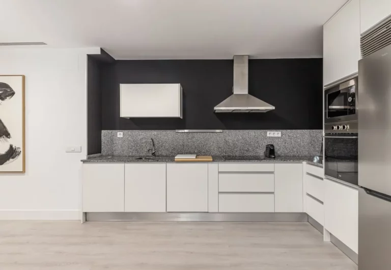 Cocina blanca abierta en el apartamento Queen's Retiro I, Madrid