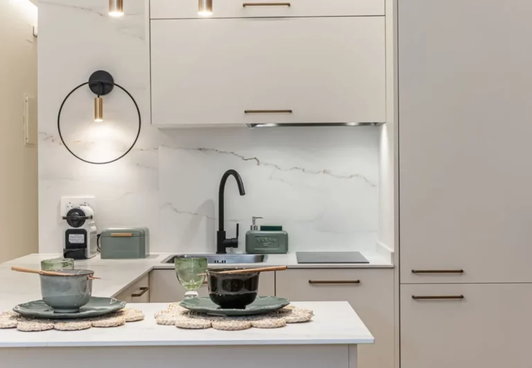 Cocina en blanco con grifería negra en el apartamento Queen's Retiro IV, Madrid