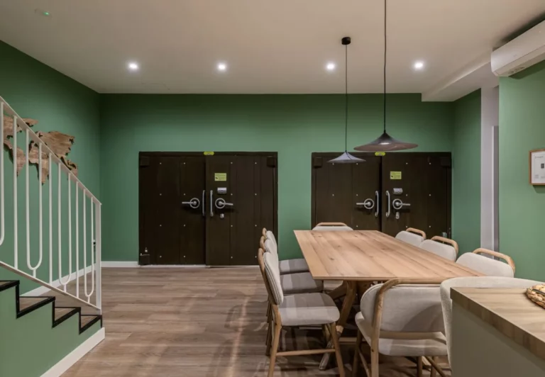Comedor compartido con mesa larga de madera en el coliving The Queen's Bernabéu, Chamartín, Madrid