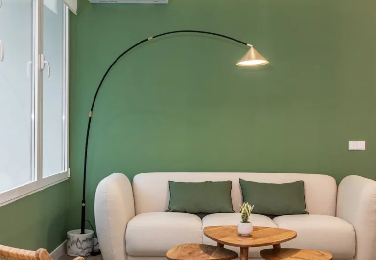 Sofá y lámpara de arco del salón compartido en el coliving The Queen's Bernabéu, Chamartín, Madrid