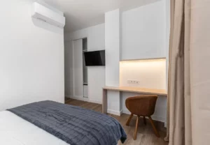 Escritorio, televisión y armario en la habitación Queen's Bernabéu IV, coliving en Chamartín, Madrid