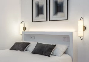 Cabecero blanco con dos cuadros abstractos en la habitación Queen's Bernabéu V, coliving en Chamartín, Madrid
