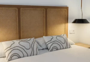 Cabecero de rejilla con cojines estampados en la habitación Queen's Bernabéu VI, coliving en Chamartín, Madrid