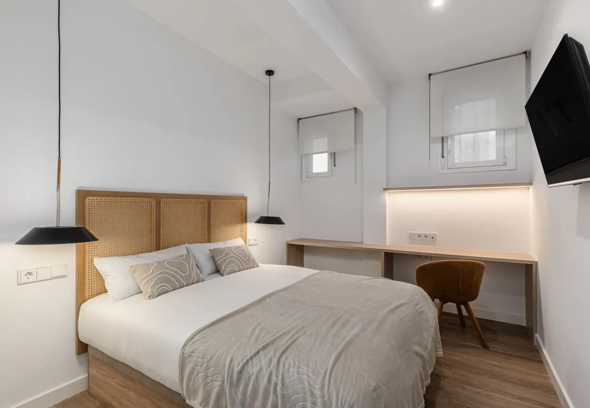 Dormitorio con cabecero de rejilla y escritorio en la habitación Queen's Bernabéu VII, coliving en Chamartín, Madrid