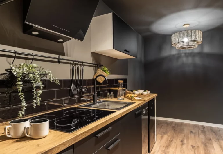 Cocina en negro mate con encimera de madera en el apartamento Queen's Chueca I, Madrid