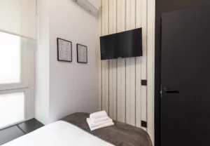 Televisión y puerta de la habitación individual, Queen's Coliving Chamberí I, coliving en Ríos Rosas, Chamberí, Madrid