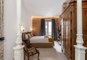 Columna de hierro y armario antiguo en la habitación Queen's House Chueca IV, hotel boutique en Chueca, Madrid
