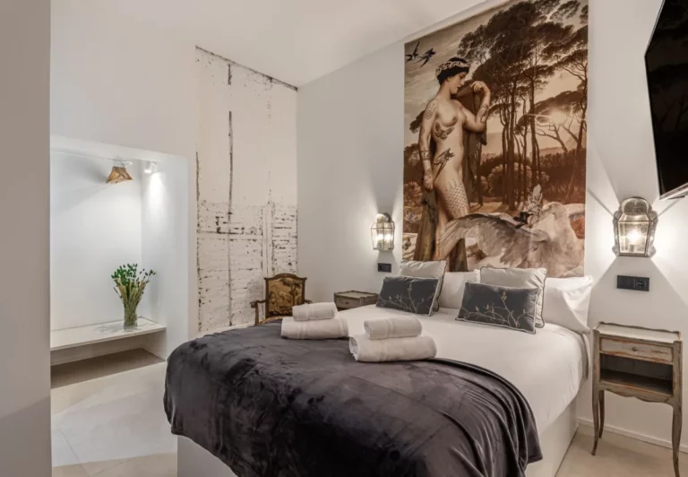 Cama bajo el mural de inspiración grecorromana en la habitación Queen's House Chueca V, hotel boutique en Chueca, Madrid