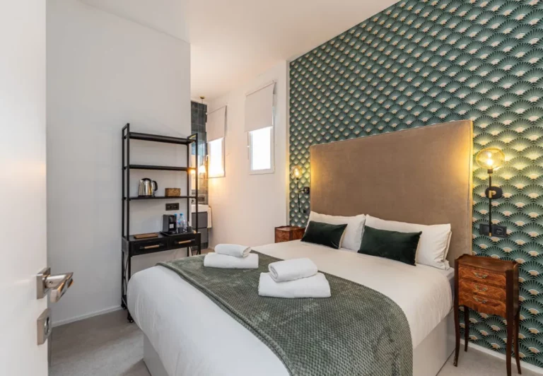 Dormitorio con papel pintado art déco verde en la habitación Queen's House Chueca VI, hotel boutique en Chueca, Madrid