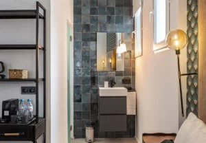 Baño de azulejo azul en la habitación Queen's House Chueca VI, hotel boutique en Chueca, Madrid