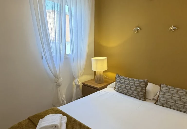 Dormitorio con ventana y lámpara en el apartamento Queen's Nuevos Ministerios I, Madrid