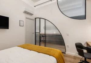 Cristalera en arco y escritorio en la habitación Queen's Olavide II, coliving en Chamberí, Madrid