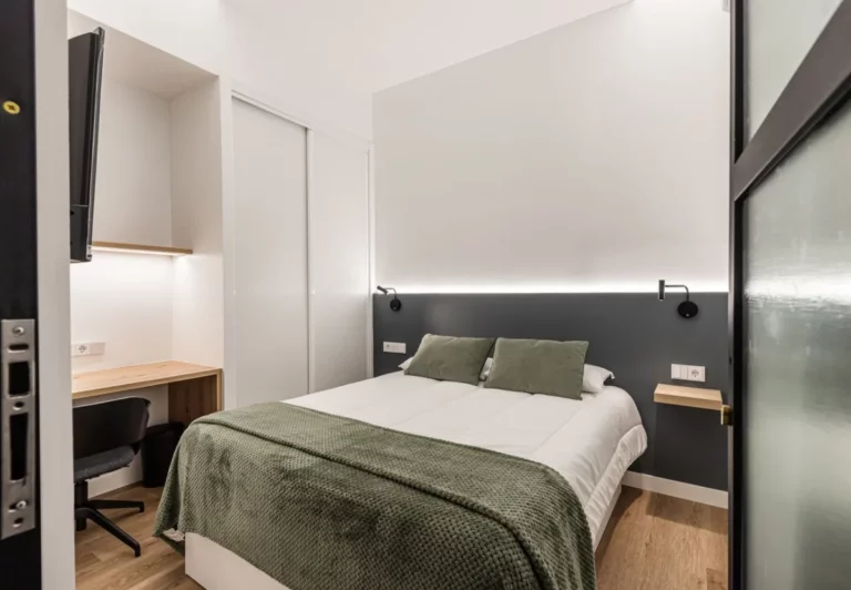 Dormitorio en tonos verde salvia con escritorio en la habitación Queen's Olavide VII, coliving en Chamberí, Madrid