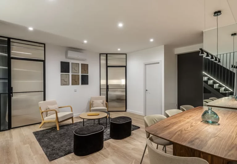 Comedor con mesa grande de madera en el coliving The Queen's Plaza España, Argüelles, Madrid