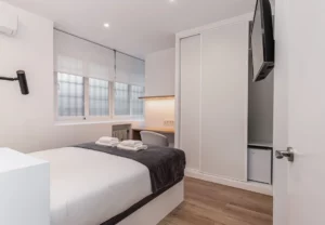 Armario empotrado blanco y ventana, Queen's Plaza España I, coliving en Argüelles, Madrid