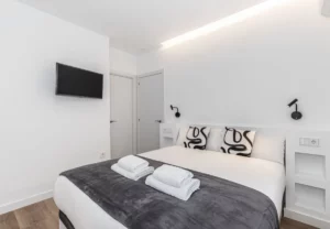 Televisión frente a la cama, Queen's Plaza España I, coliving en Argüelles, Madrid