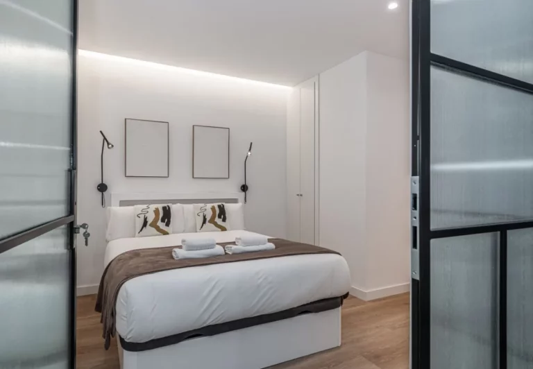 Cama de matrimonio con dos cuadros sobre el cabecero, Queen's Plaza España II, coliving en Argüelles, Madrid
