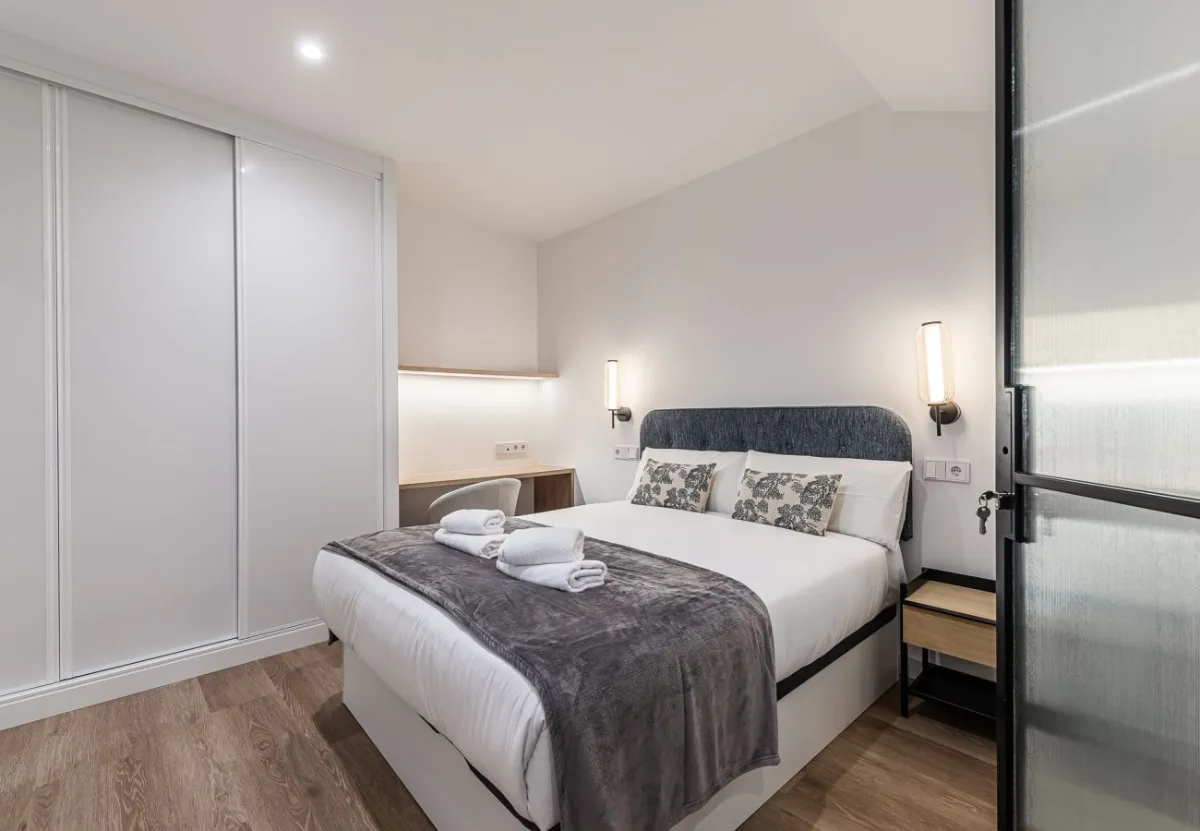 Cama de matrimonio con cabecero tapizado y armario empotrado, Queen's Plaza España V, coliving en Argüelles, Madrid