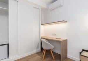 Escritorio con silla junto al armario, Queen's Plaza España VI, coliving en Argüelles, Madrid