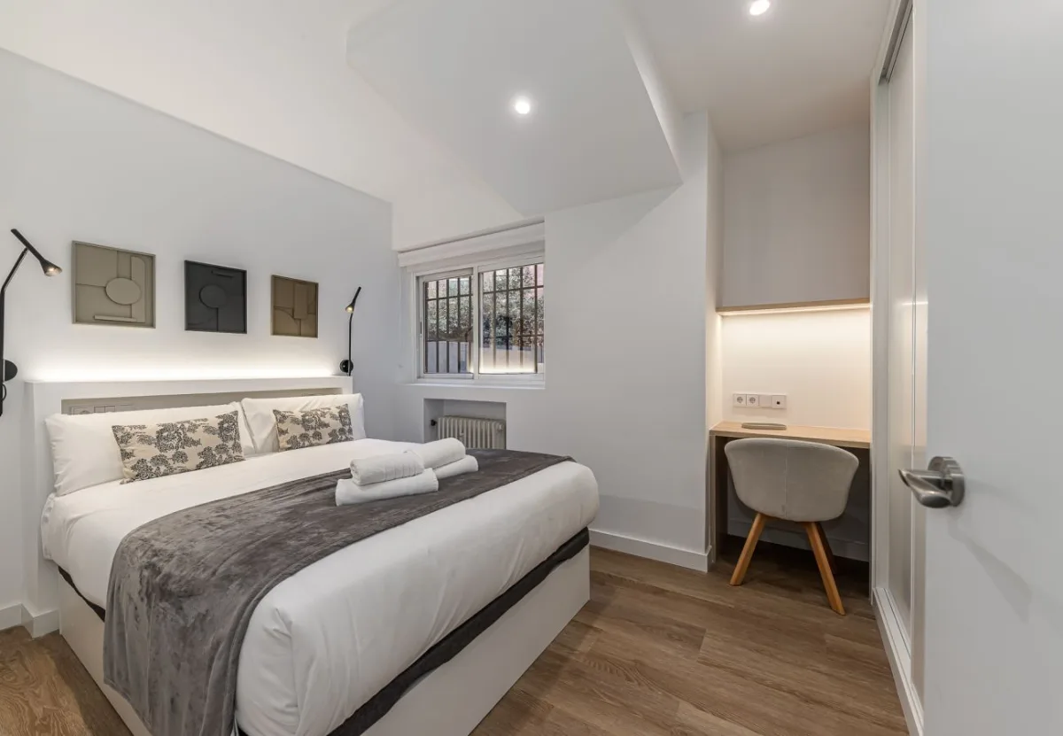 Cama de matrimonio con tres cuadros sobre el cabecero, Queen's Plaza España VII, coliving en Argüelles, Madrid