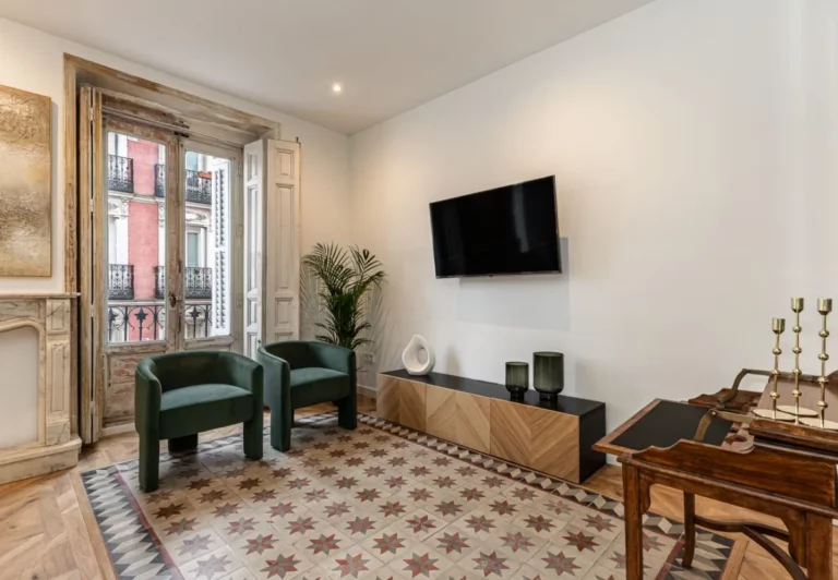 Rincón del salón con butacas y televisión en el apartamento Queen's Plaza Mayor IV, Madrid
