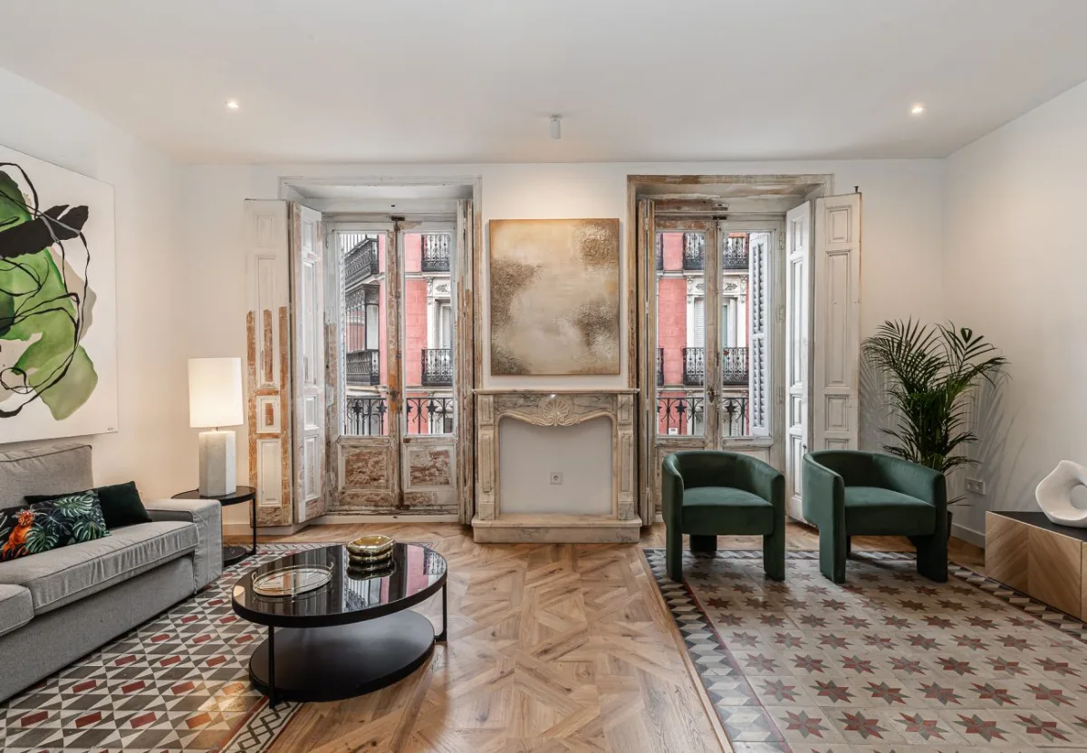 Salón con balcones y suelo de madera en espiga en el apartamento Queen's Plaza Mayor IV, Madrid