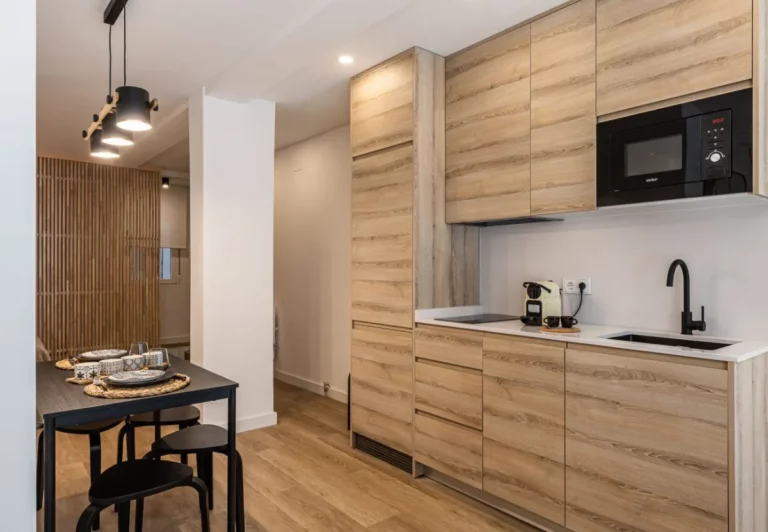 Cocina en madera clara con horno y microondas en el apartamento Queen's Salamanca I, Madrid