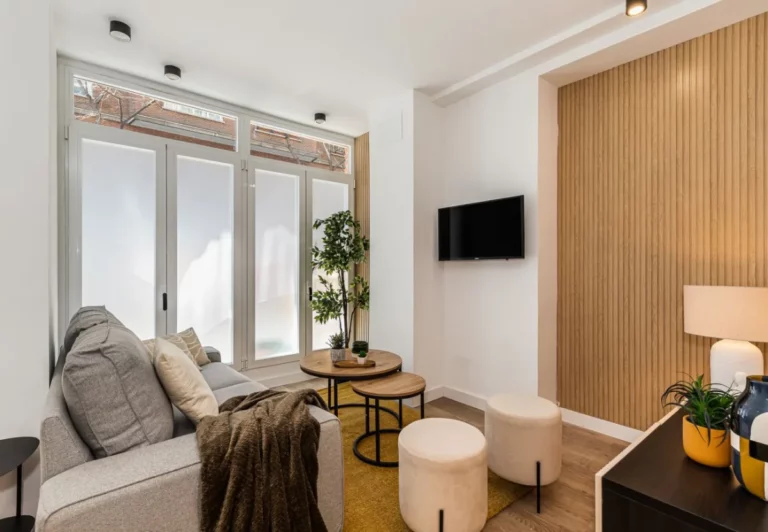 Salón con sofá y ventanales en el apartamento Queen's Salamanca I, Madrid