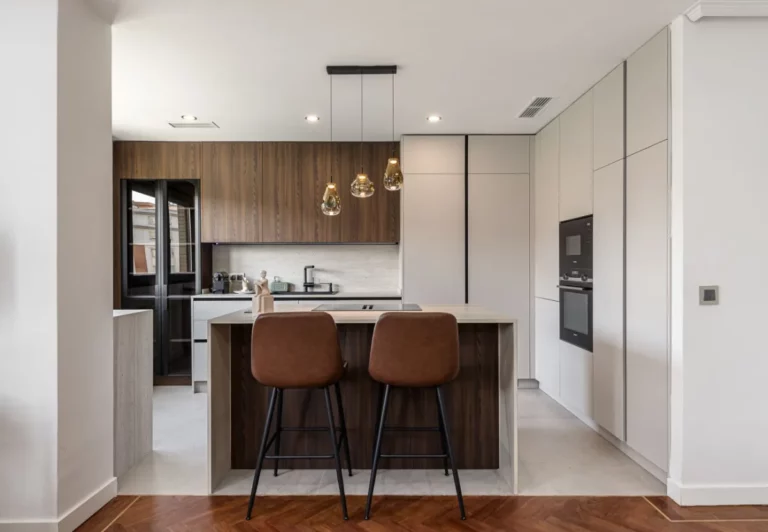 Cocina en madera oscura y blanco en el apartamento Queen's Salamanca III, Madrid