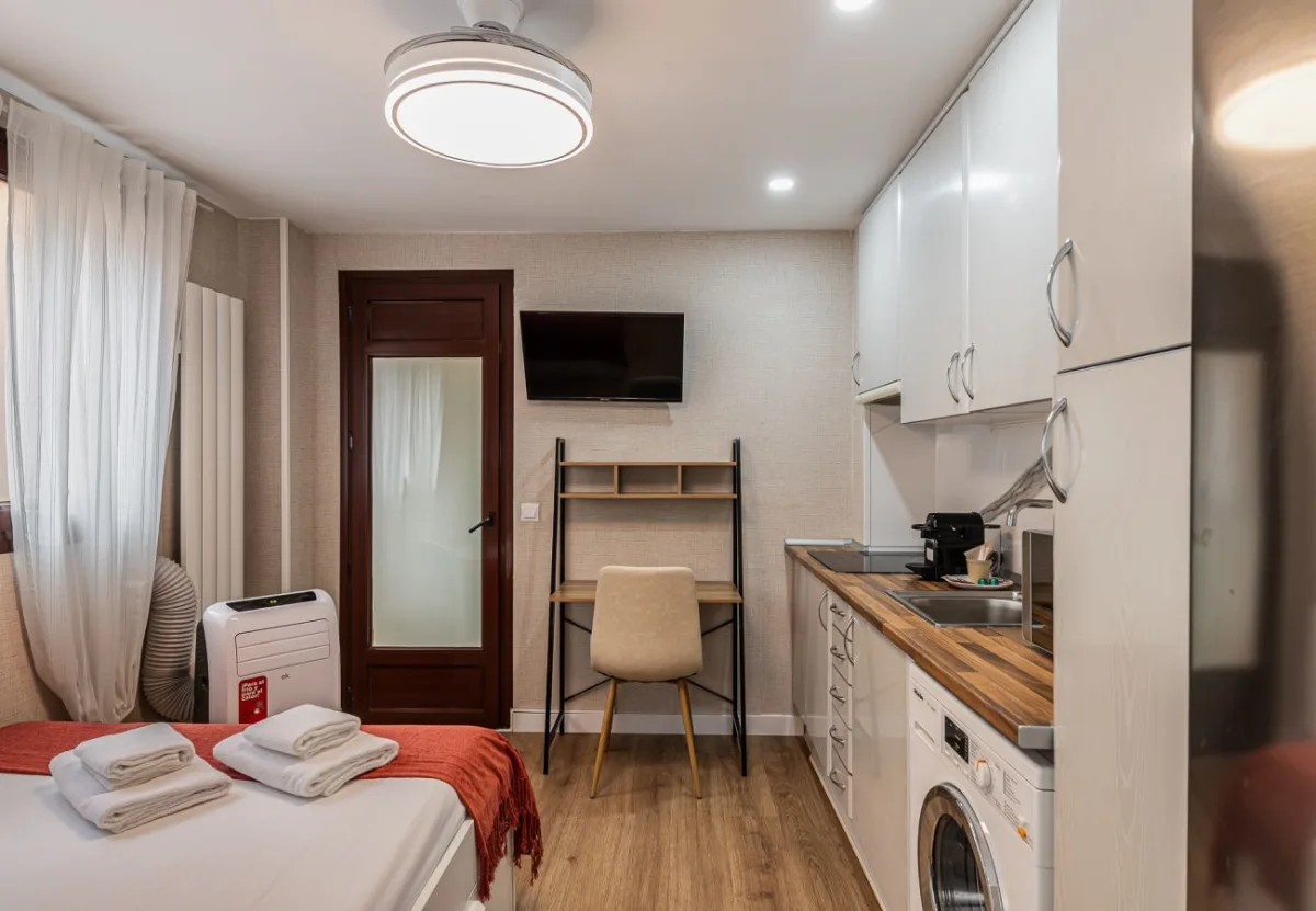 Espacio abierto con zona de dormitorio y cocina en el apartamento Queen's Salamanca IV, Madrid