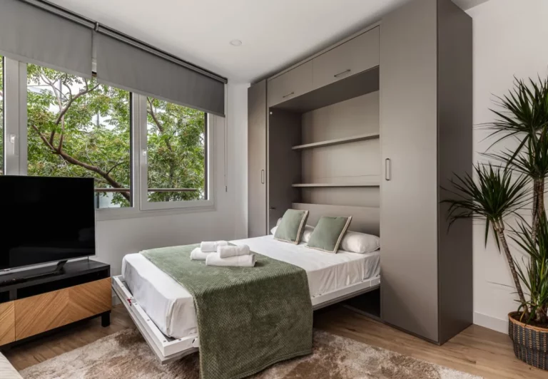 Cama de matrimonio abatible desplegada en el salón en el apartamento Queen's Serrano, Madrid